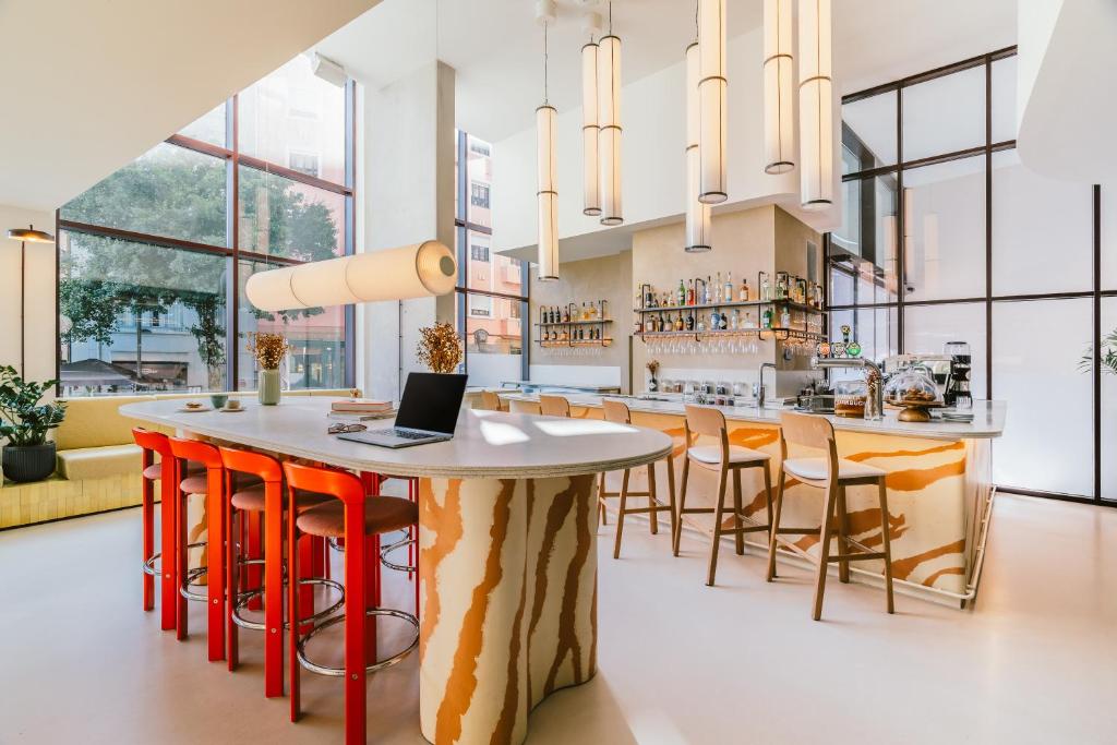 Una cocina con una mesa con una computadora portátil encima. en The Social Hub Porto, en Oporto