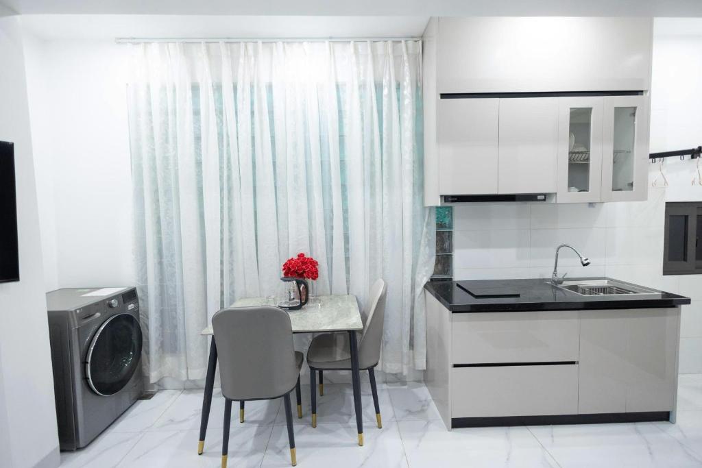 una cucina con tavolo, sedie e lavatrice di Giảm Giá 25 Phần Trăm- Homestay - Kim Mã - Giang Văn Minh a Hanoi