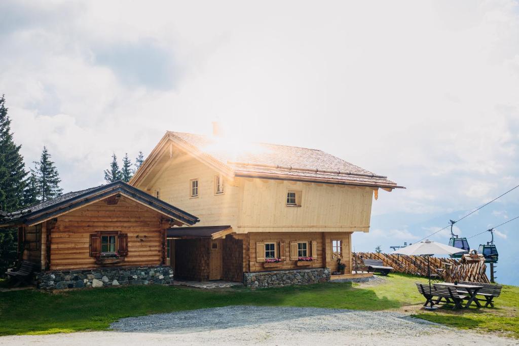 a large wooden house with a bench in front of it at Chalet Vierlauchen in Bramberg am Wildkogel