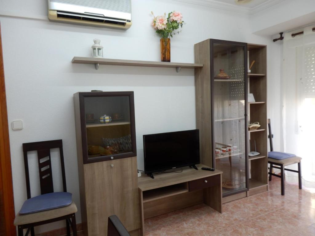 a living room with a tv and a entertainment center at Apartamento funcional y acogedor in L'Ametlla de Mar