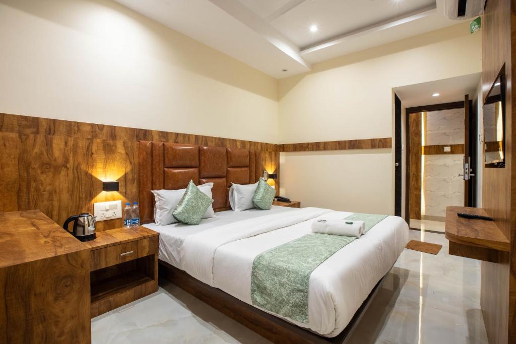 Un dormitorio con una cama grande con cabecero de madera. en Hotels Heraa International, en Bombay