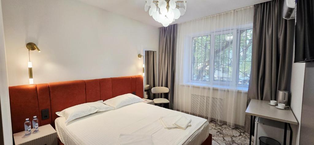 a hotel room with a bed and a window at Naya Hotel in Almaty