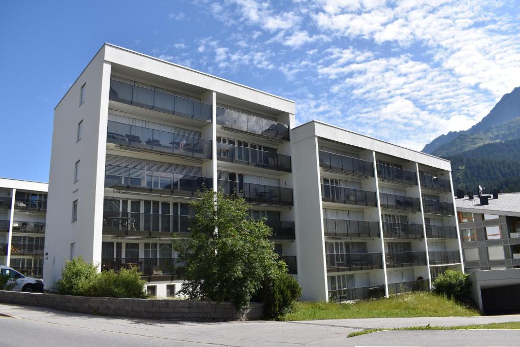 a large white building with mountains in the background at Ladina 65 (319 St) in Lenzerheide
