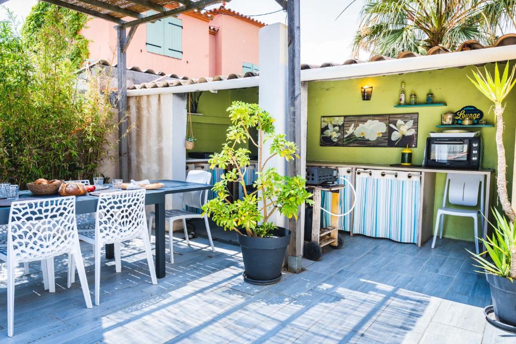un patio extérieur avec une table et des chaises dans l'établissement Belle villa spacieuse et tranquille, à Saint-Nazaire