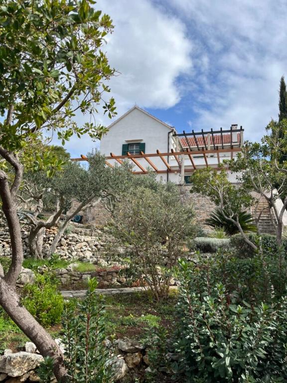 a house on top of a hill with trees at Villa Tramonto in Sutivan