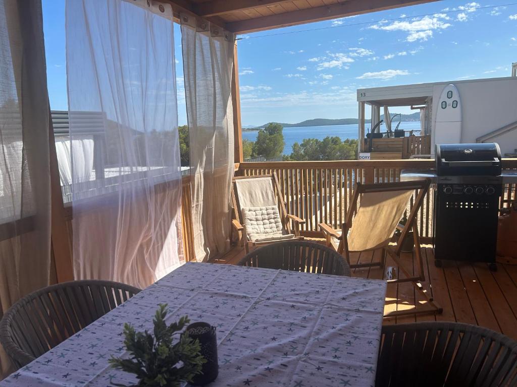 a porch with a table and chairs on a deck at Mobile home La Bella in Drage