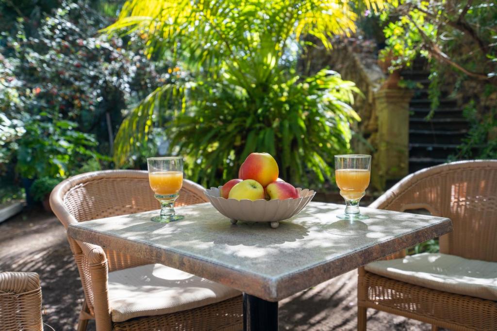 einen Tisch mit einer Schale Obst und zwei Gläsern Orangensaft in der Unterkunft Vivelorural Casita Vintage, Santa Brígida in Santa Brígida
