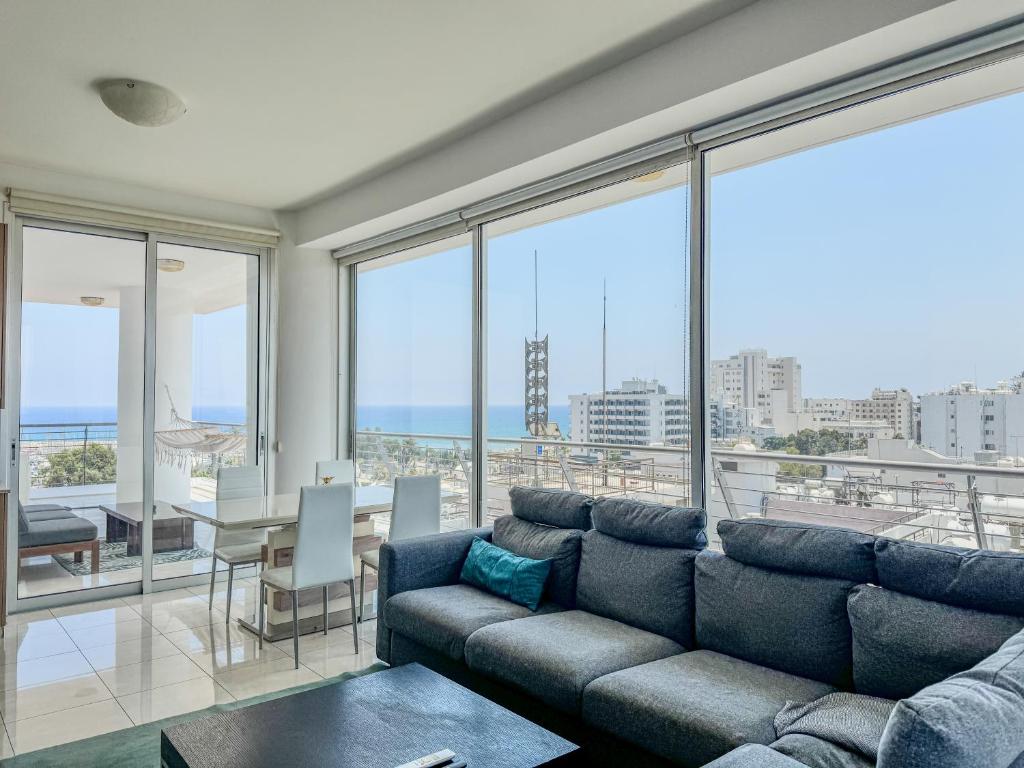 un salon avec un canapé et une table dans l'établissement Stunning Sea & City View Apt - 3 min Walk to Beach, à Larnaka