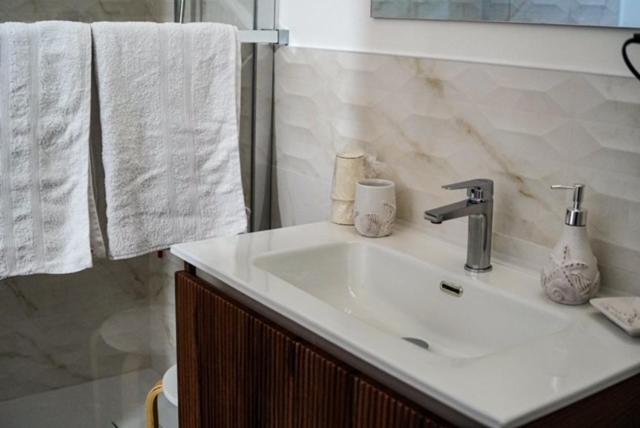 a bathroom with a white sink and towels at Burgi's House in Pizzo