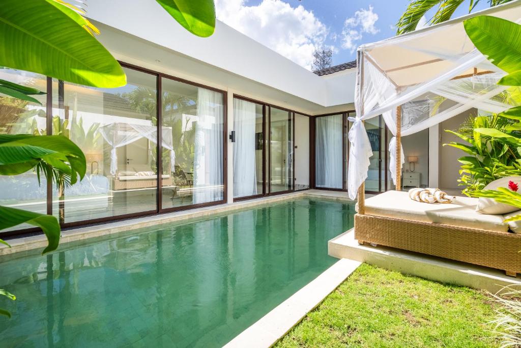 an infinity pool in a villa with glass walls at Frelin Villas - 1 BR, 2 BR Luxury Villa Complex in Kerobokan
