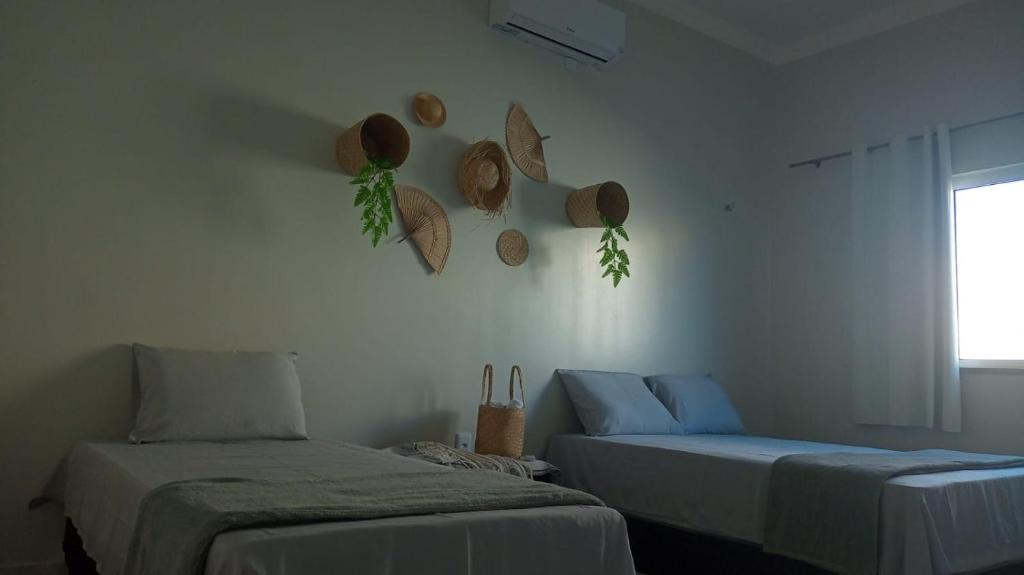 a room with two beds and hats on the wall at Vida no Paraíso Lagoinha in Tigre