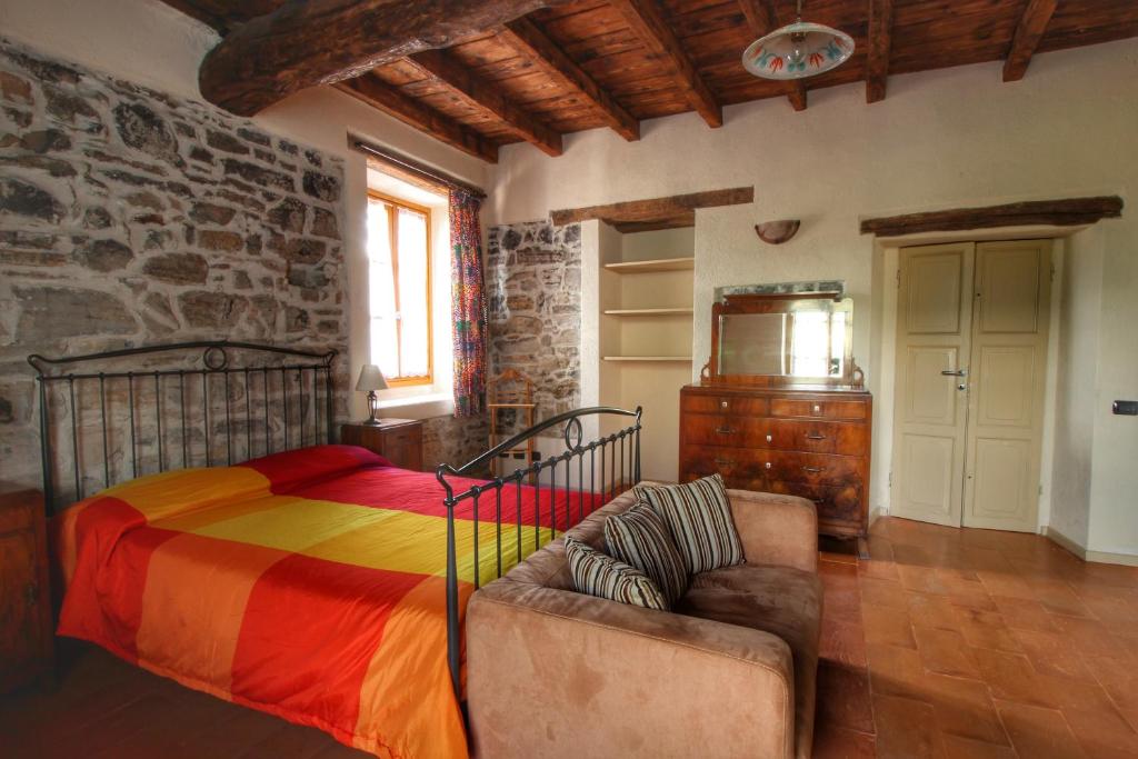 sypialnia z łóżkiem i kanapą w obiekcie Country House Cozzena w mieście Maslianico