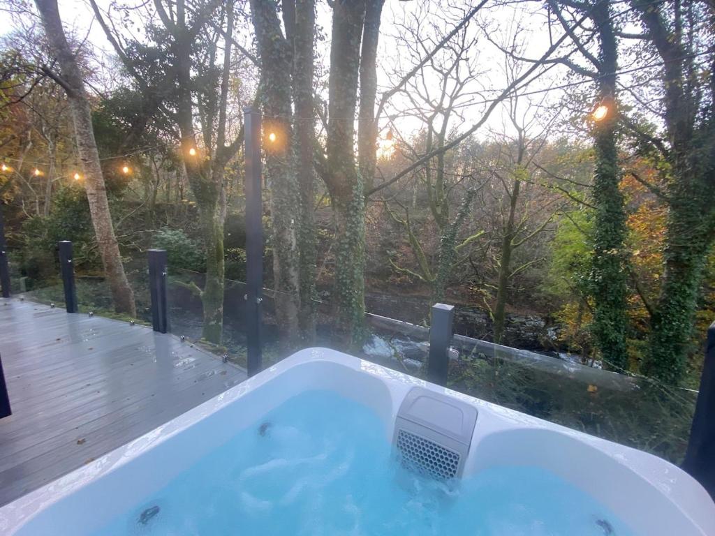 bañera frente a una ventana con árboles en P59 - Riverstone with hot tub, en Bethesda
