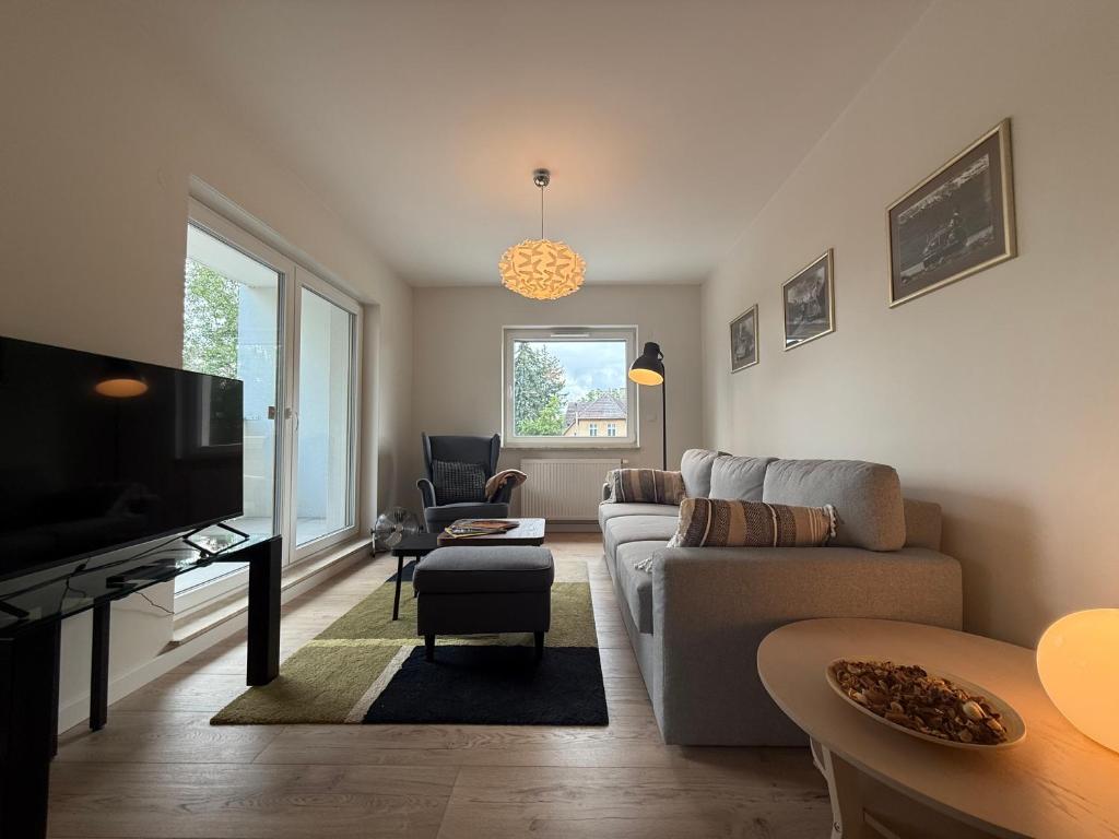 Una sala de estar con un sofá y un televisor. en Apartament Kostrzyńska 59 m2, en Gorzów Wielkopolski
