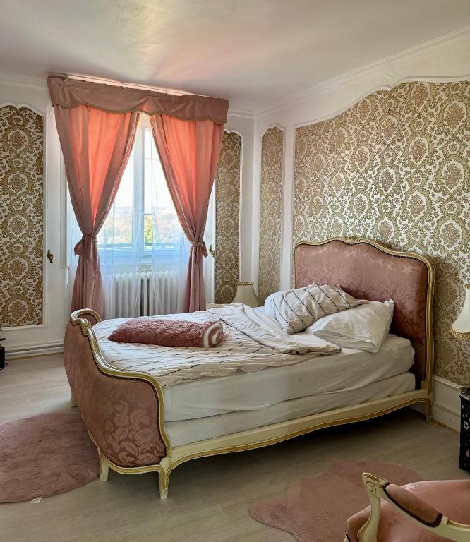 - une chambre avec un lit à baldaquin et une fenêtre dans l'établissement 24 H Circuit Le Mans, au Mans