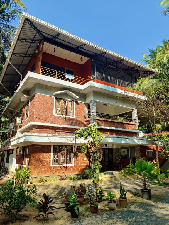 a red brick building with plants in front of it at lakeview homestay in Trikarpur