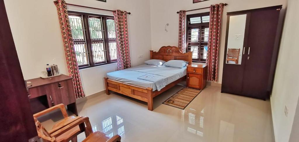 a bedroom with a bed and a dresser and windows at lakeview homestay in Trikarpur