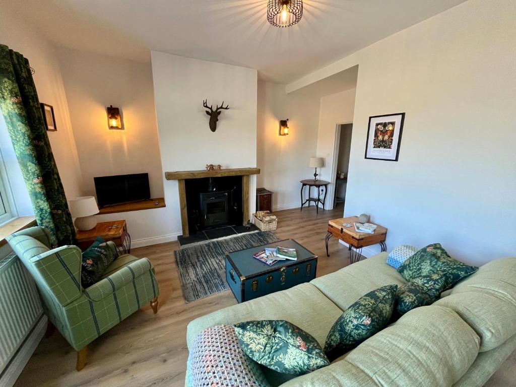 ein Wohnzimmer mit Couch und Kamin in der Unterkunft Cosy cottage near Saltburn & Whitby in Boosbeck