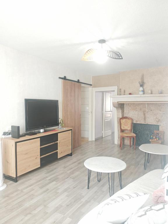 un salon avec une télévision à écran plat et des tables dans l'établissement chez Émile côté face maison entière, 3 chambres, 2 salles de bains,jardin et terrasse, à Humes