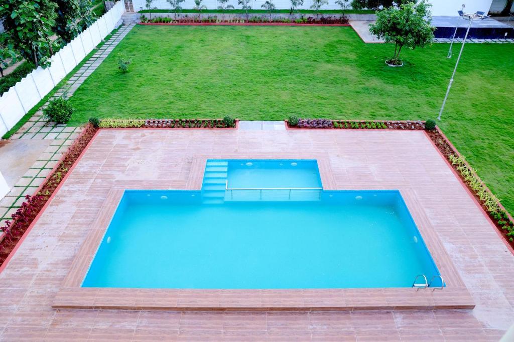 a swimming pool in the middle of a yard at Agastya FarmsPoolAC4BHKParty Villa25 PaxWifi in Hyderabad