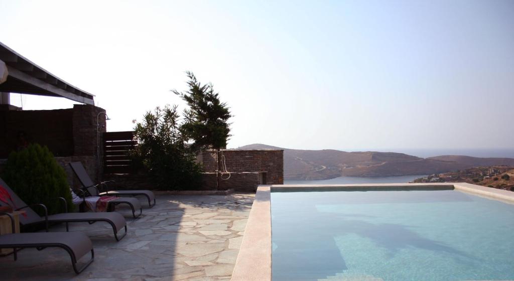 uma piscina com cadeiras e vista para uma montanha em Aigaion House em Otziás