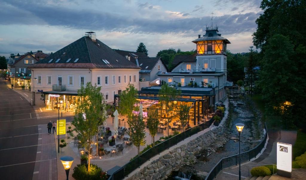 budynek z oświetloną wieżą w mieście w obiekcie Hotel Post Wrann w mieście Velden am Wörthersee