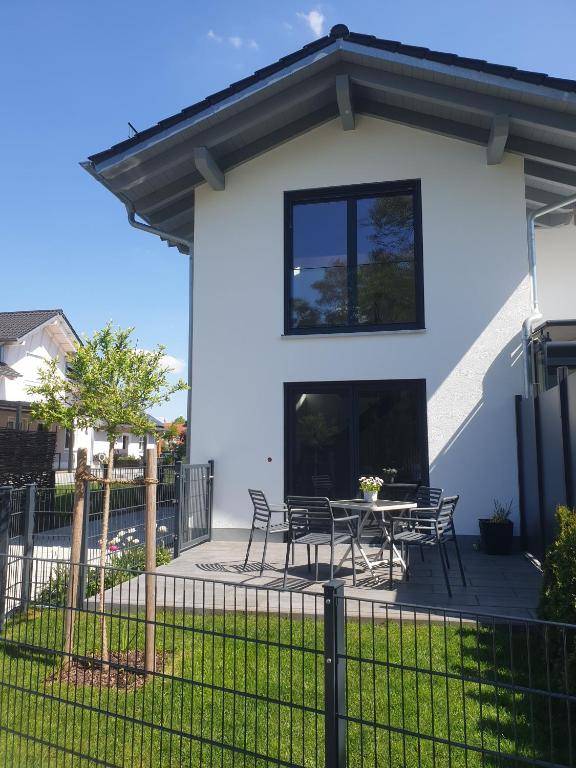 a white house with a table and chairs at Appartement an der alten Linde in Weil