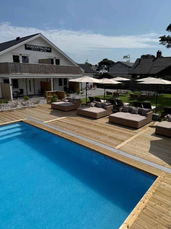 a swimming pool with lounge chairs and umbrellas at Stugcentralen Lägenhetshotell &amp; Stugor in Halmstad
