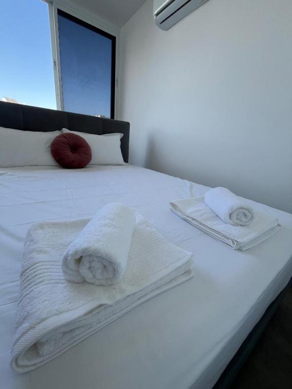 a white bed with towels on top of it at דירה בוטיק in Rishon LeẔiyyon