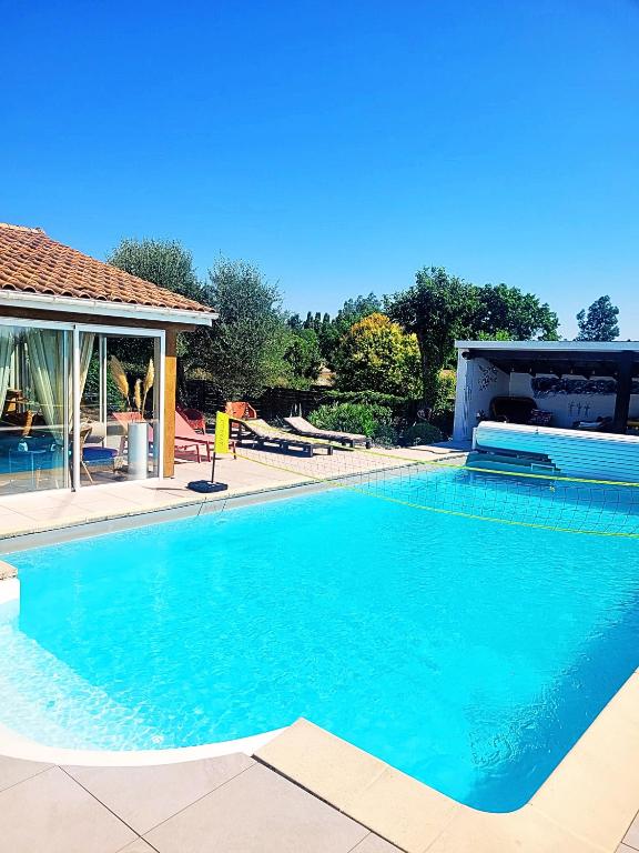 une grande piscine bleue dans une cour dans l'établissement Chambre Vigne, piscine spa fitness, à Lugon et l’Ile du Carney