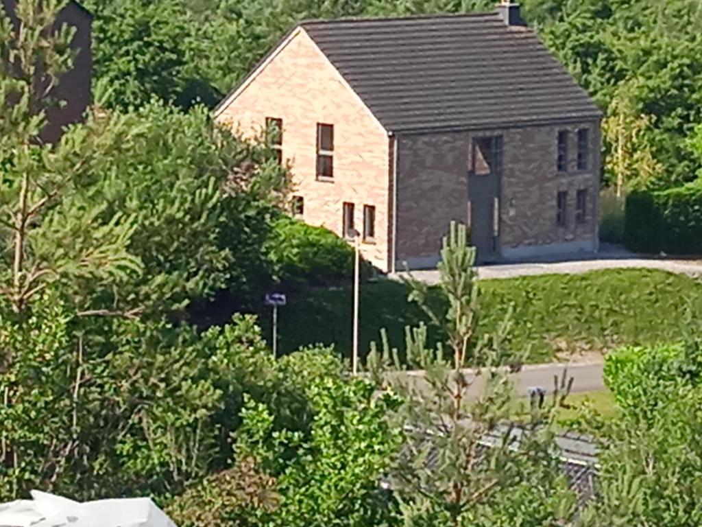 a house in the middle of a yard with trees at Au coin de détente in Durbuy