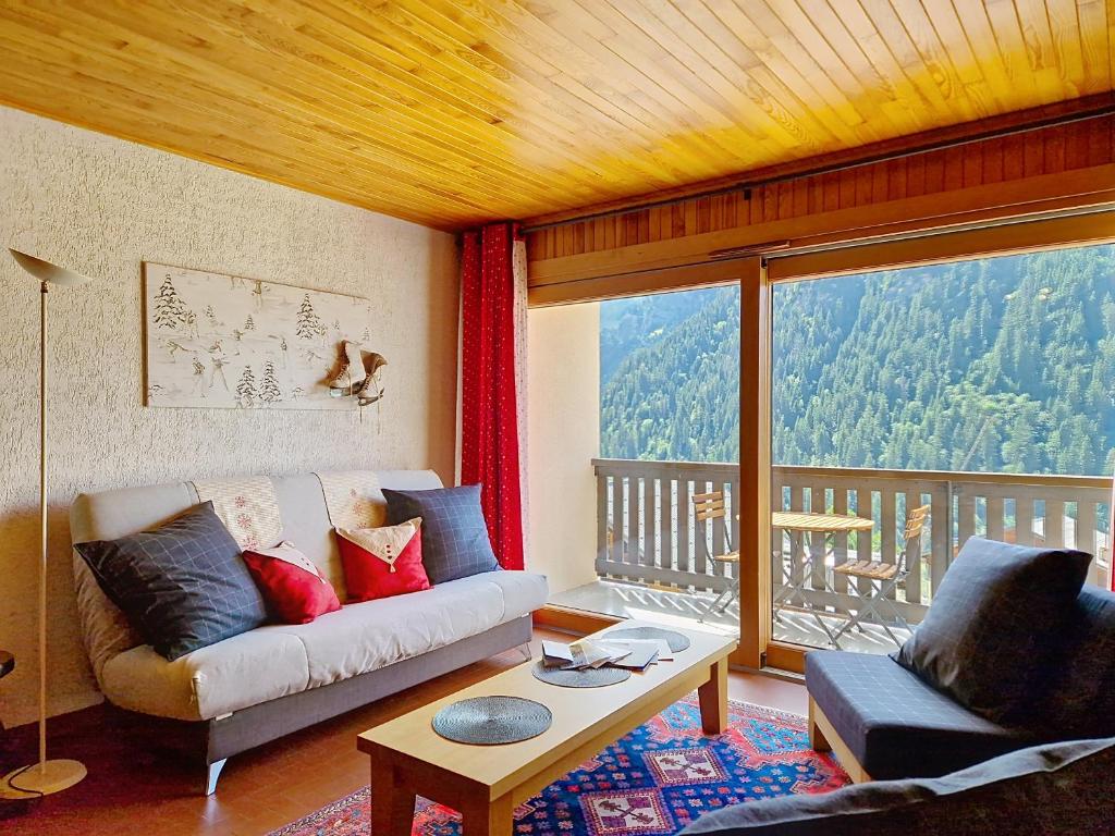 un salon avec un canapé et une grande fenêtre dans l'établissement RESIDENCE RSA18 SWIMMING POOL & CENTER 6 pers, à Châtel