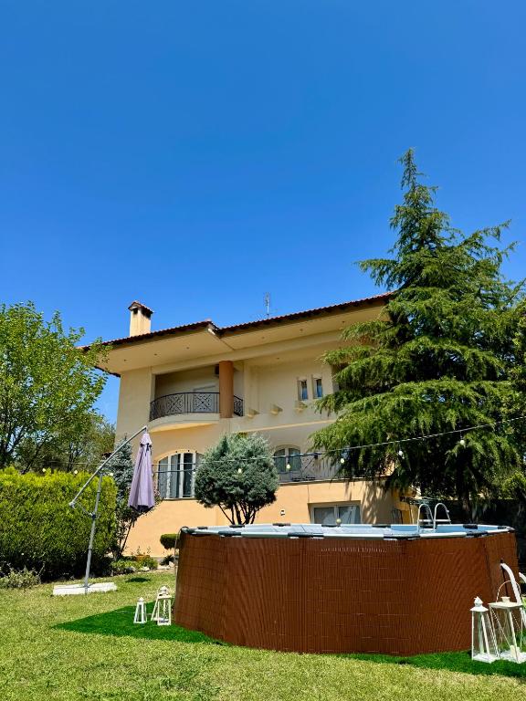 a house with a pool and a tree in front of it at E L urban villa. in Epanomi