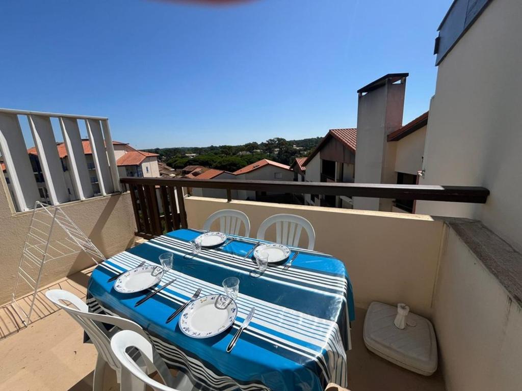 une table et des chaises bleues et blanches sur un balcon dans l'établissement Studio cabine avec terrasse, 4 couchages, lumineux, cadre portuaire, tout équipé. - FR-1-413-134, à Capbreton