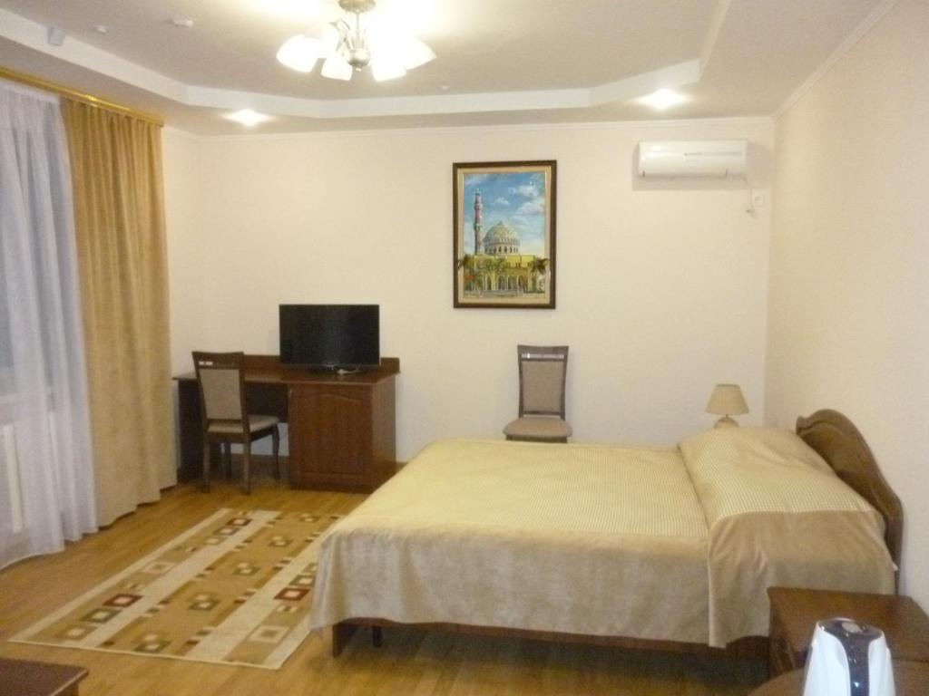 a bedroom with a bed and a television at Hotel VIARDO on Timiryazeva 17 in Almetyevsk