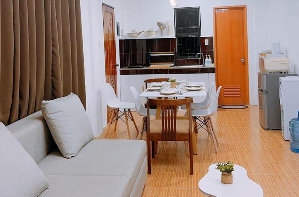 a living room with a white couch and a table at Family Island House in Casa Verde Mati City in Mati