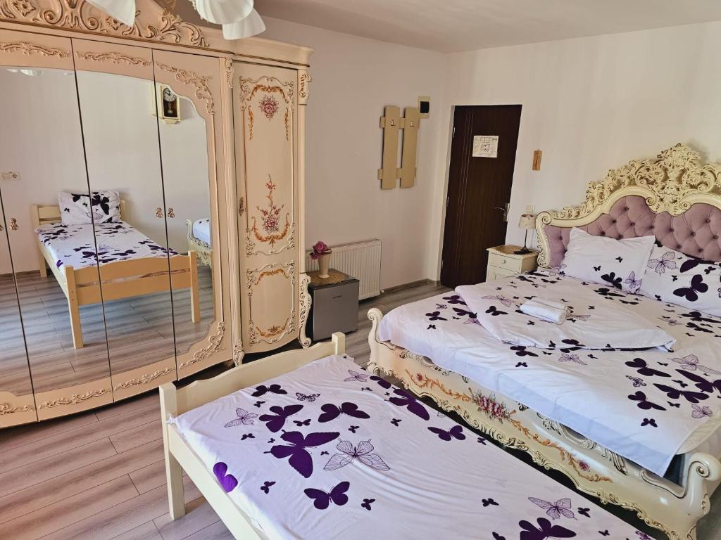 Un dormitorio con dos camas y un espejo. en Aliando, en Sighişoara