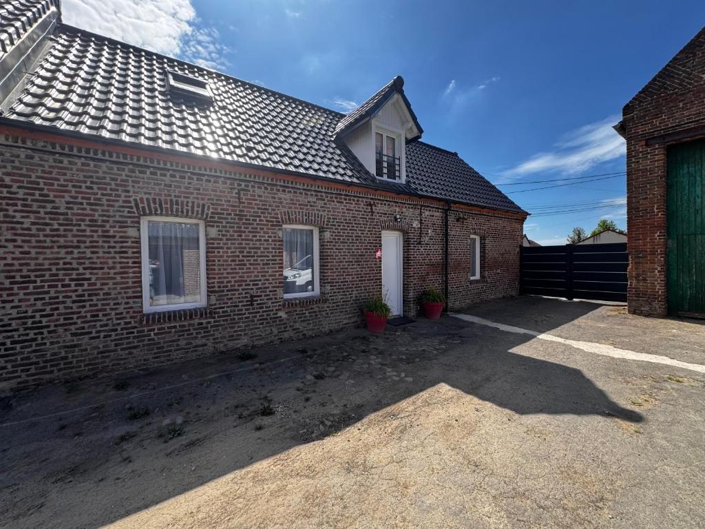 a brick house with a driveway in front of it at La Pause d'Antan 
