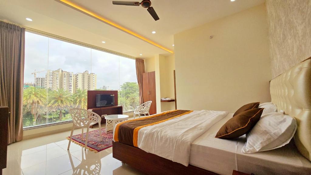 a bedroom with a bed and a large window at LakeWood Gardenia Boutique Hotel in Bengaluru