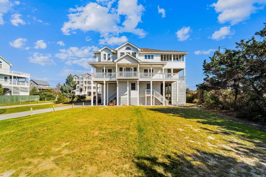 a large white house with a large yard at By the See in Waves