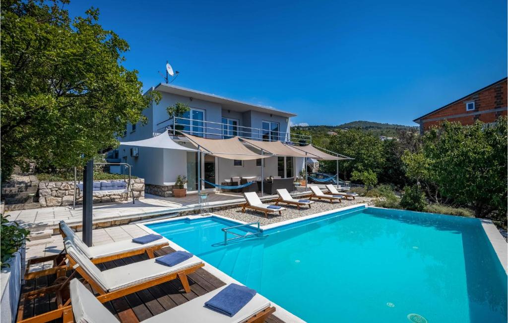 a villa with a swimming pool and lounge chairs at Amazing Home In Crikvenica in Crikvenica