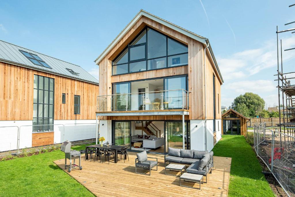 Somerford KeynesにあるInfinity Lodge ML05 Lower Mill The Cotswoldsの木製のデッキとガラスのある家