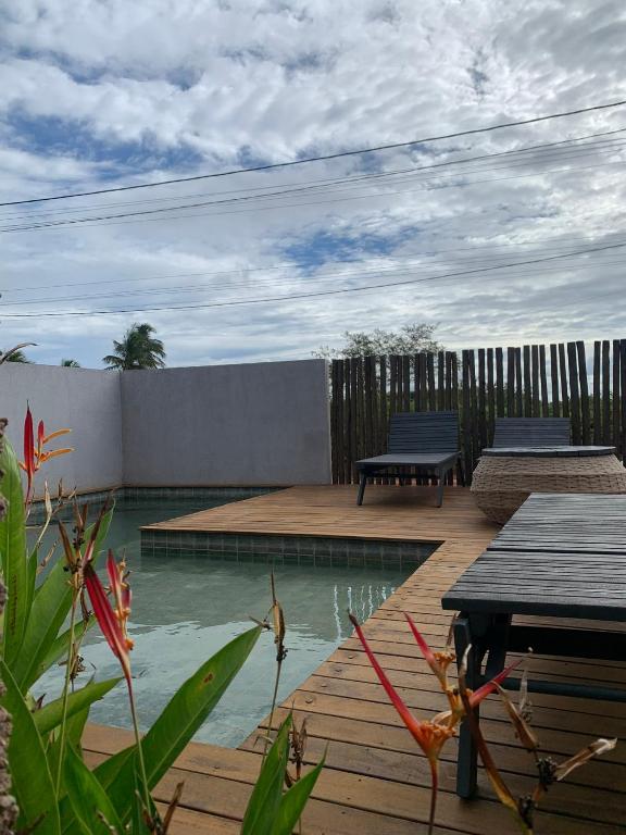 a backyard with a pool and a wooden deck at Dourados Villas Suites in São Miguel do Gostoso