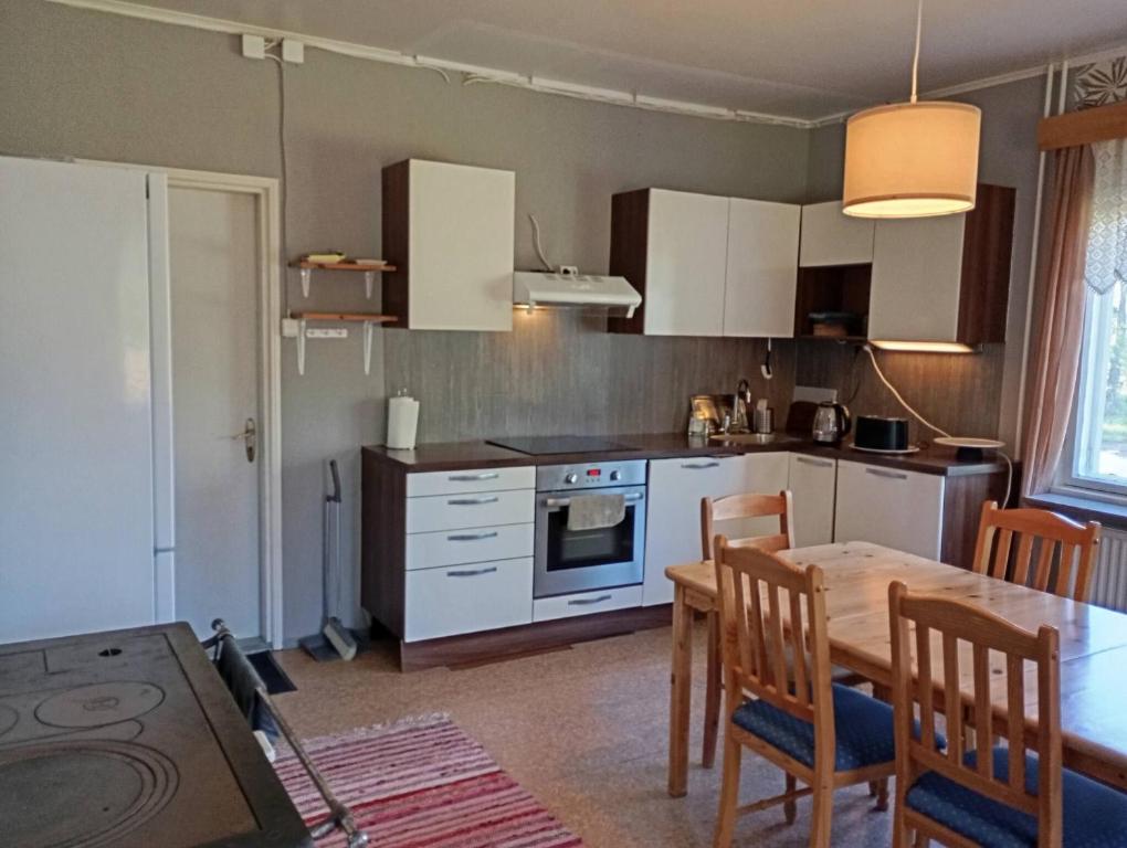 a kitchen with a table and a dining room at sydtorp charming old house in the countryside in Rosendal