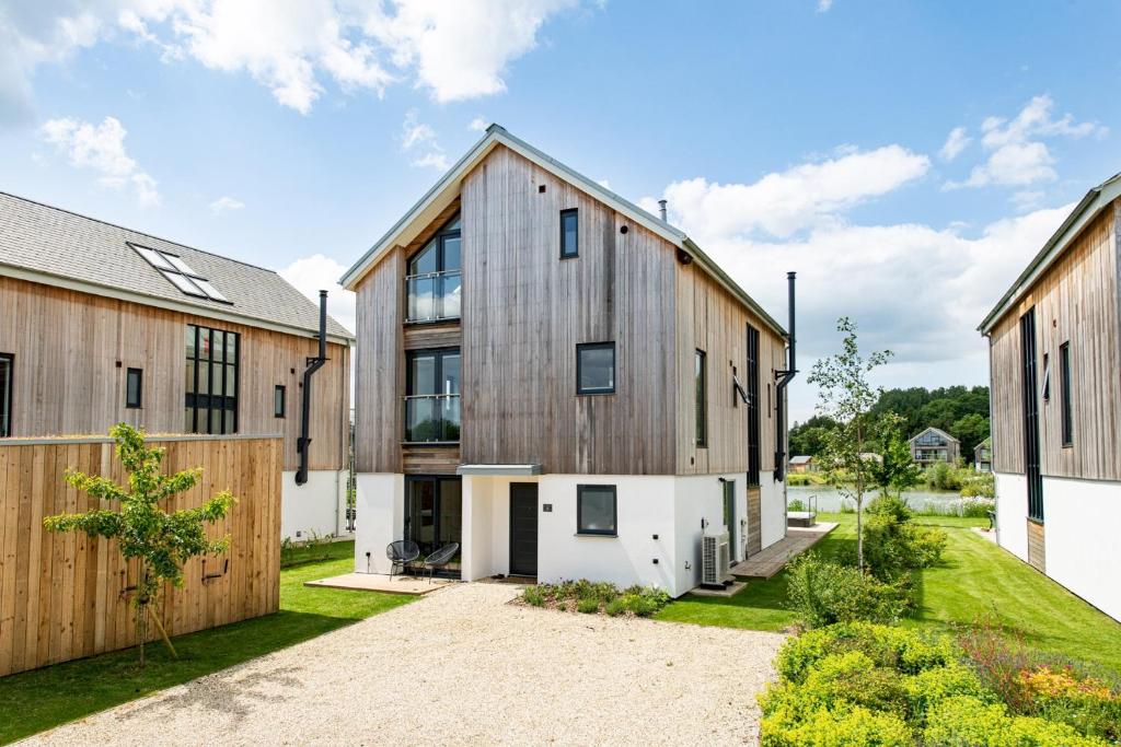 an exterior view of a barn conversion with wooden buildings at Huron House ML06 Lower Mill Estate Cotswolds in Somerford Keynes