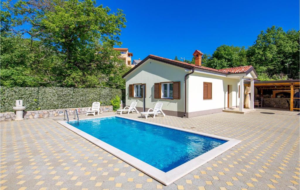 a villa with a swimming pool in front of a house at Gorgeous Home In Rukavac With Kitchen in Rukavac