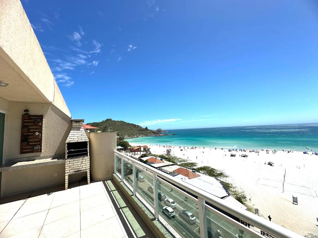 une vue sur la plage depuis le balcon d'un condo dans l'établissement Luxuosa Cobertura Vista Mar- Praia Grande, à Arraial do Cabo