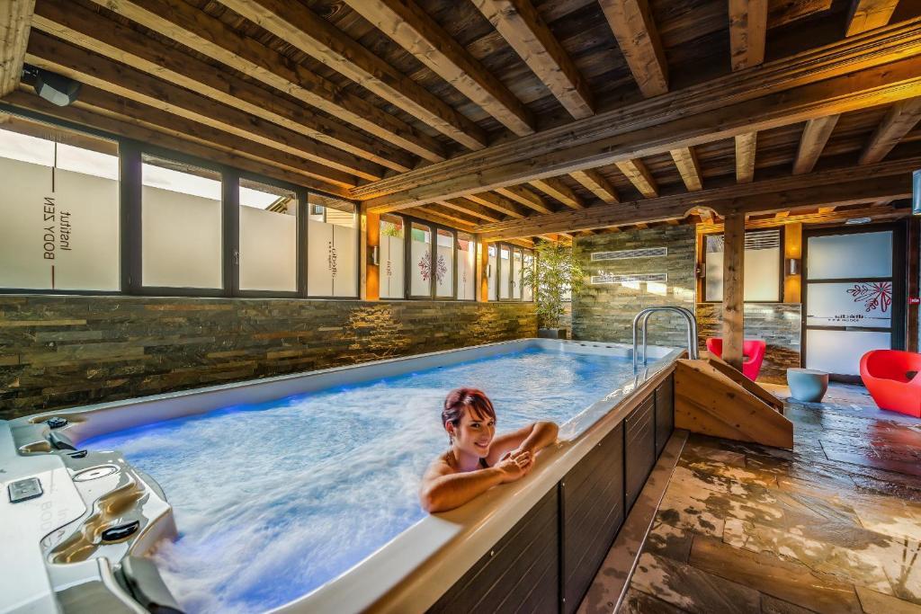 a woman in a hot tub in a house at La Maison Rouge in Barberaz