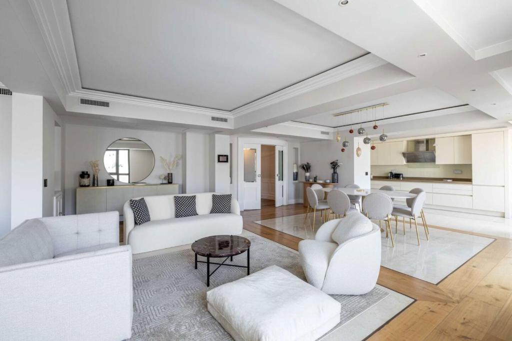 un soggiorno con mobili bianchi e tavolo di Résidence Carlton Riviera - Cannes a Cannes