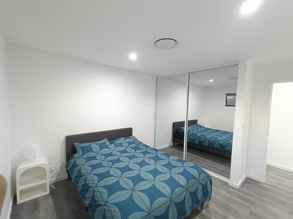 un dormitorio con una cama y un espejo en Comfortable and Modern Queen Room in Guildford Home - NR9, en Guildford